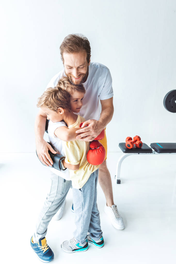 pai abraçando filhos em luvas de boxe
 - Foto, Imagem