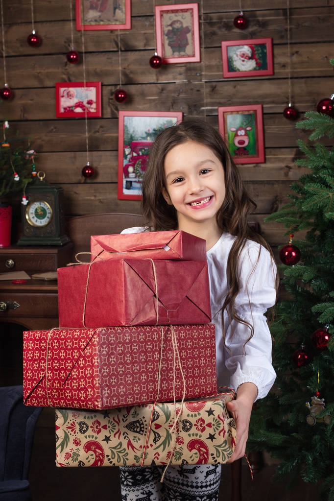 Gelukkig klein meisje glimlachend 7 jaar oud houdt Kerstcadeaus - Foto, afbeelding