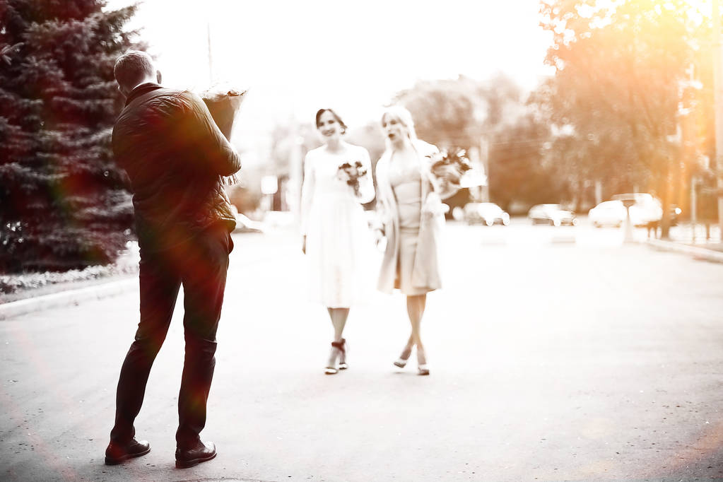 Invités joyeux au mariage, vue arrière de l'homme en costume tenant bouquet de fleurs, noir et blanc
  - Photo, image