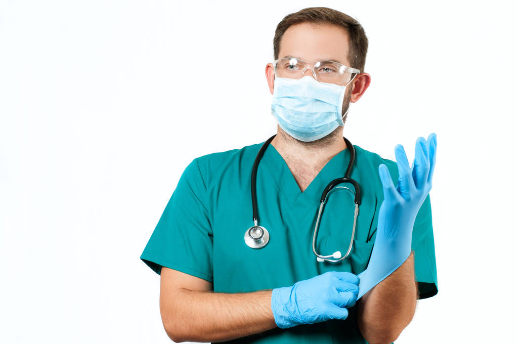 Doctor masculino con estetoscopio y máscara protectora y guantes
. - Foto, Imagen