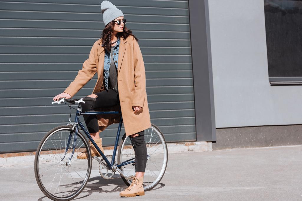  Mulher em roupa de outono sentado na bicicleta
 - Foto, Imagem