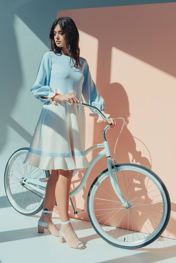 Woman in fashionable turquoise dress with bicycle - Photo, Image
