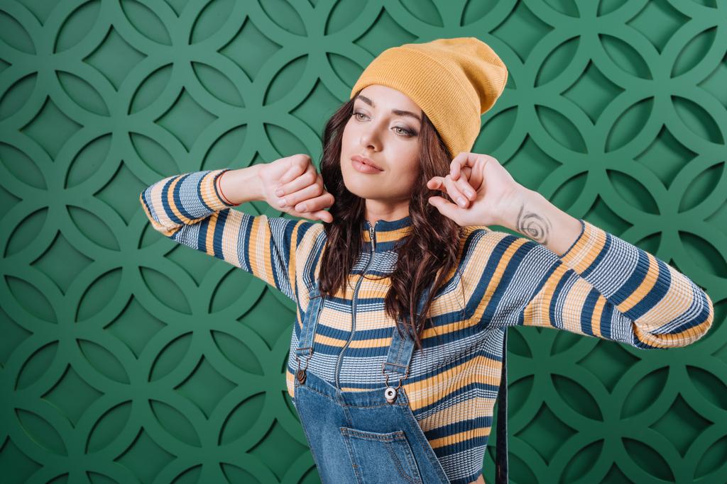 Woman posing in pullover, hat and overalls - Photo, Image