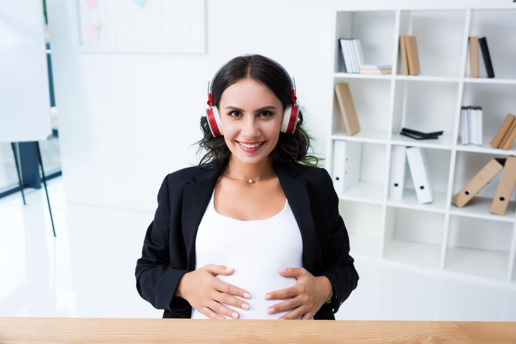 妊娠中の実業家のヘッドフォンで音楽を聴く - 写真・画像