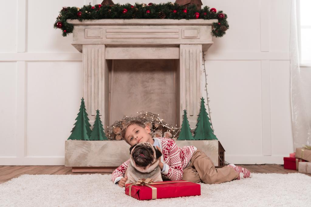 niño con regalo de Navidad y pug
 - Foto, Imagen