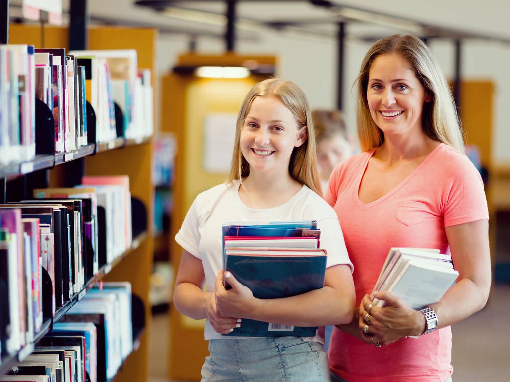 Girl and her mother in library - Photo, Image