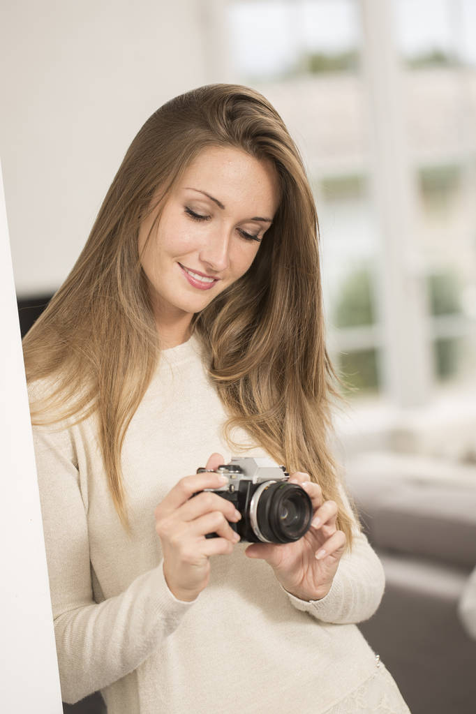 Menina alegre bonita usando câmera de foto vintage
 - Foto, Imagem