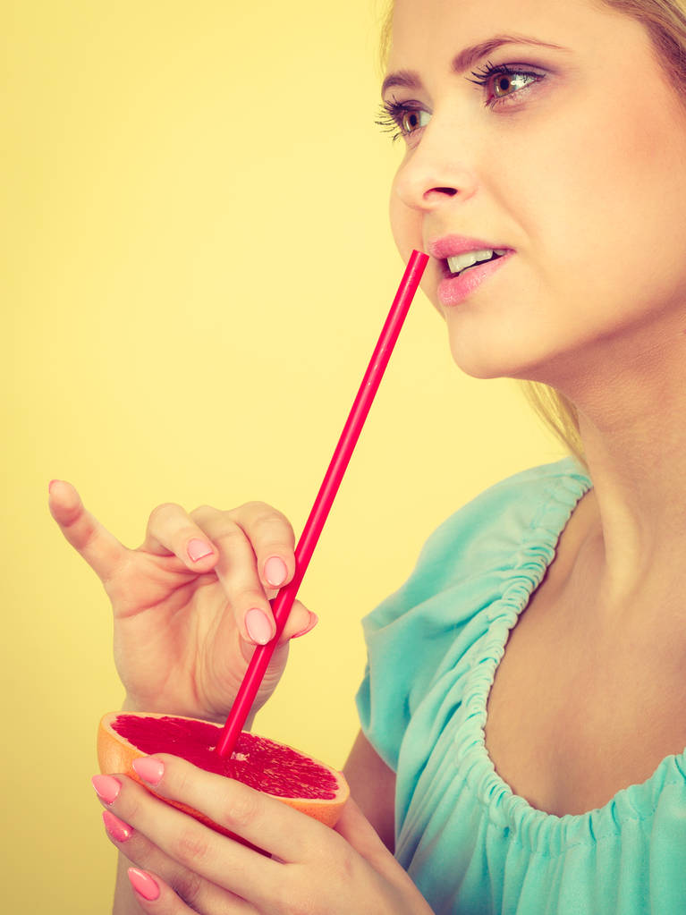 Mujer bebiendo jugo de fruta, pomelo rojo
 - Foto, imagen