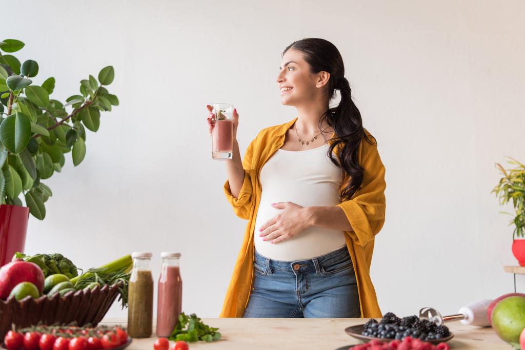 вагітна жінка зі склянкою детоксикаційного напою
 - Фото, зображення