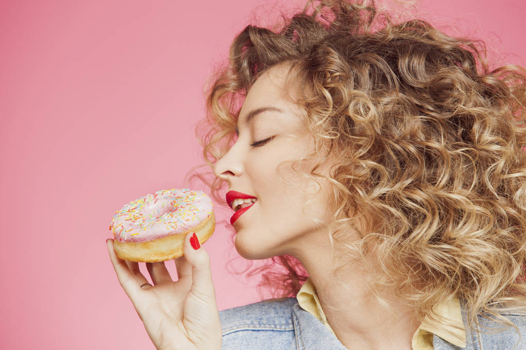 young woman put face to donut  - Photo, Image