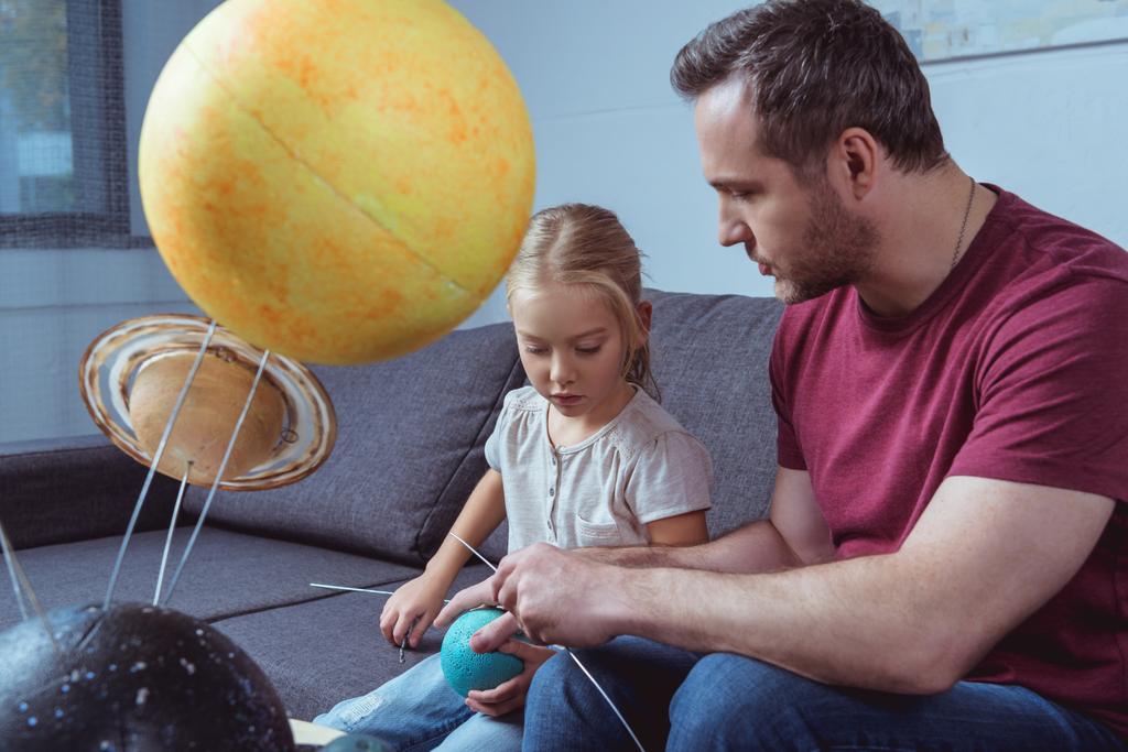 Padre e hija jugando con planetas
   - Foto, Imagen
