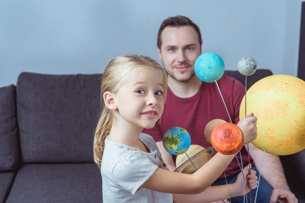 Père et fille posant avec des planètes
  - Photo, image