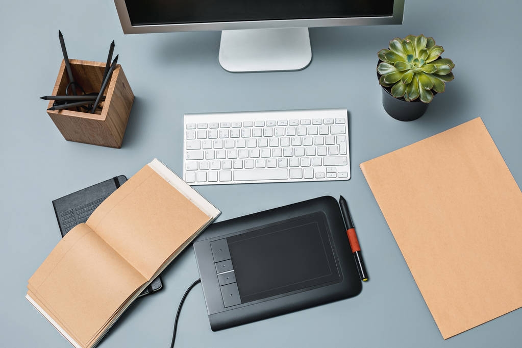 A szürke íróasztal, laptop Jegyzettömb üres lapot, kanna virág, toll és tablet retusálás - Fotó, kép