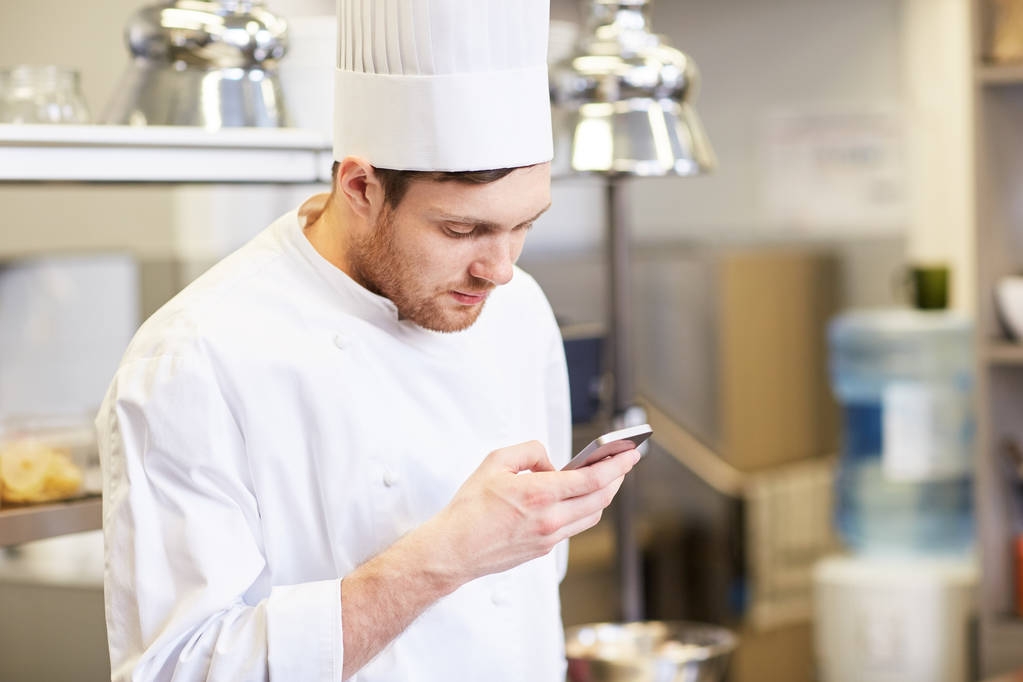 повар-повар со смартфоном на кухне ресторана
 - Фото, изображение