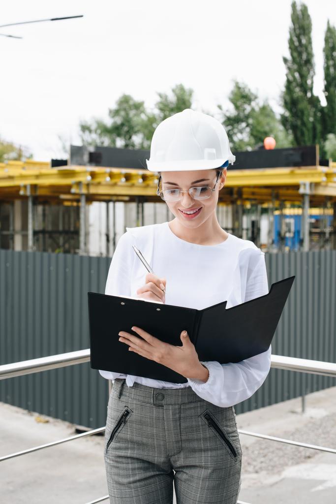 Geschäftsfrau auf Baustelle hält Ordner in der Hand - Foto, Bild