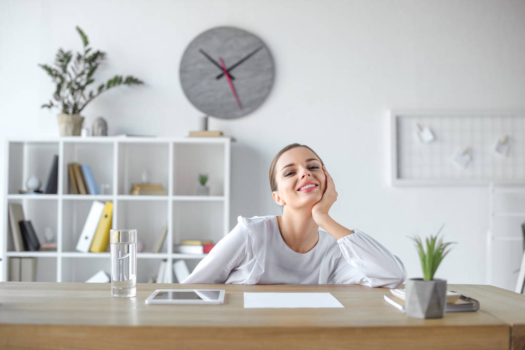 Lächelnde Geschäftsfrau am Schreibtisch im Büro - Foto, Bild