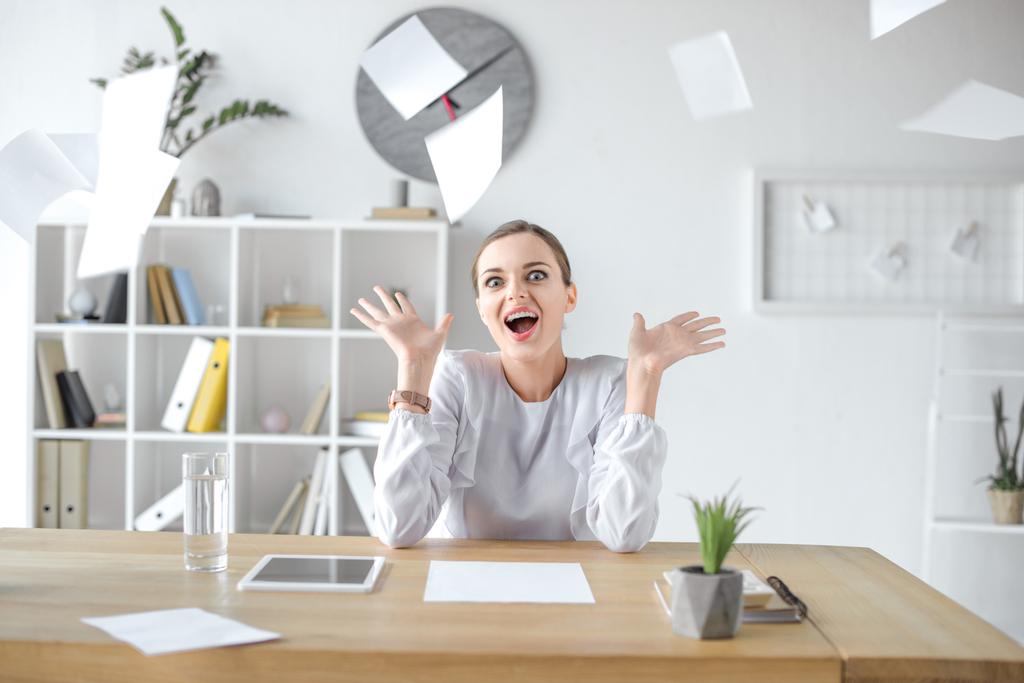 Cheerful businesswoman sitting at desk in office - Photo, Image