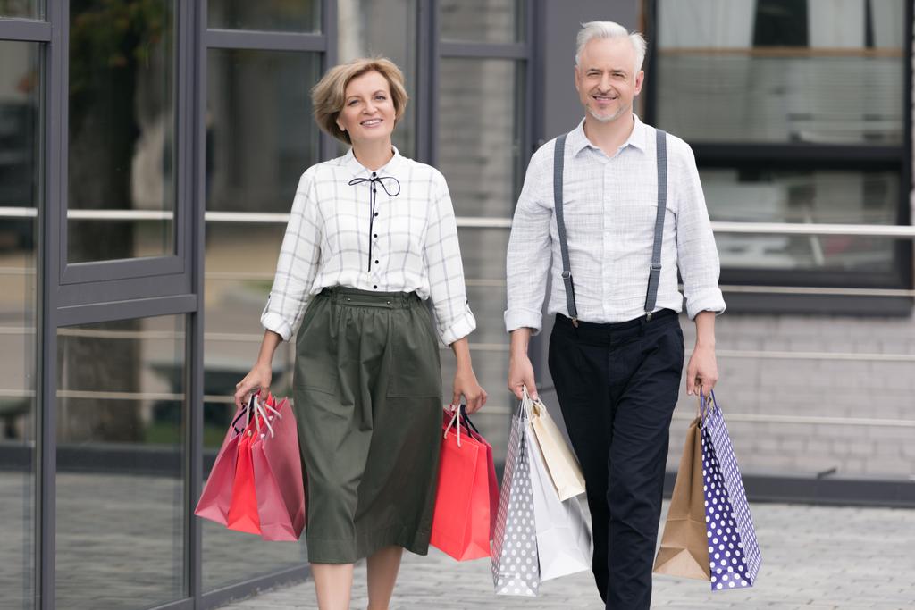 Чоловік і дружина ходять з сумками
 - Фото, зображення