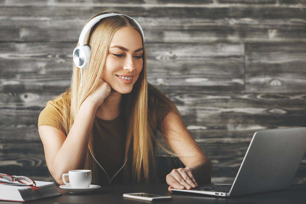 Mulher atraente ouvir música no local de trabalho
  - Foto, Imagem