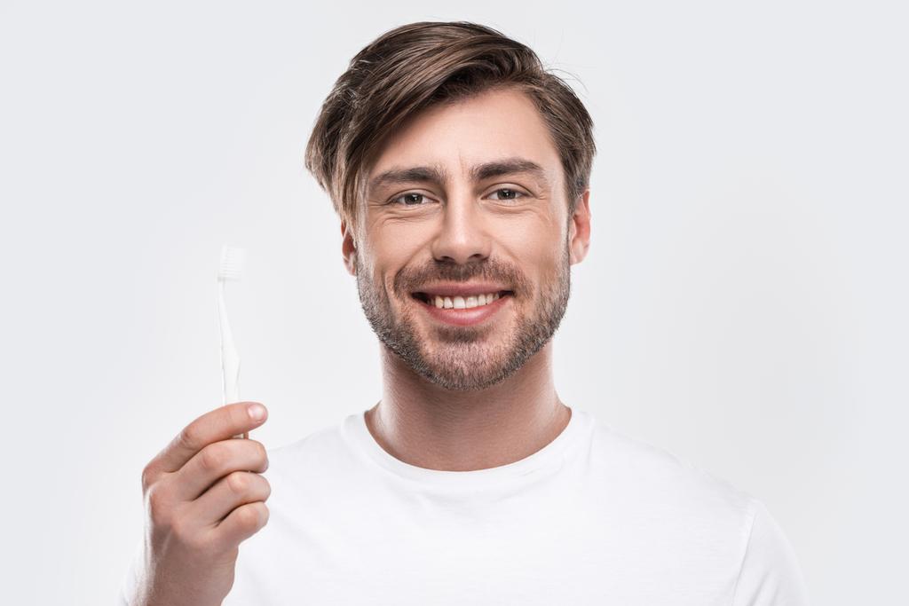 Homme tenant une brosse à dents
 - Photo, image