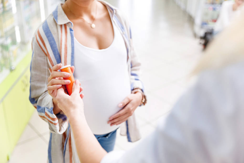 apteekki antaa pillereitä raskaana olevalle naiselle
 - Valokuva, kuva