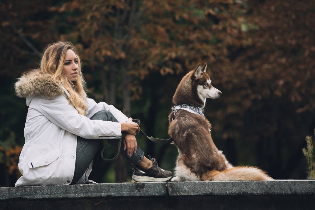 Frau sitzt mit Hund im Park - Foto, Bild
