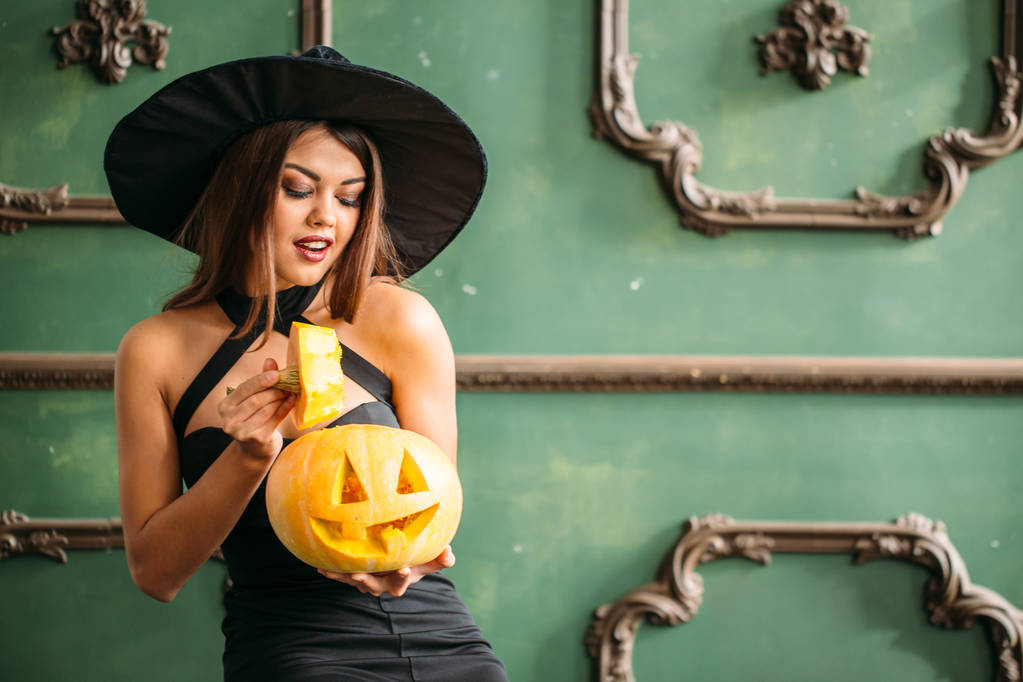 Giovane donna bionda che tiene le zucche per Halloween
 - Foto, immagini
