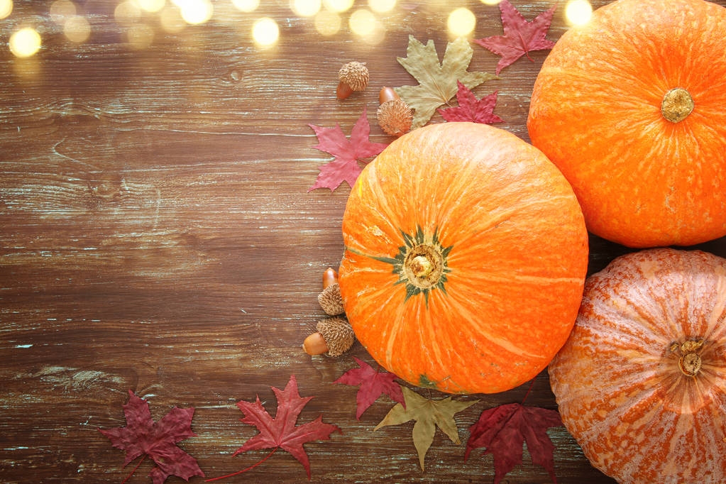 Pumpkins and autumn leaves on wooden background. thanksgiving and halloween concept - Photo, Image