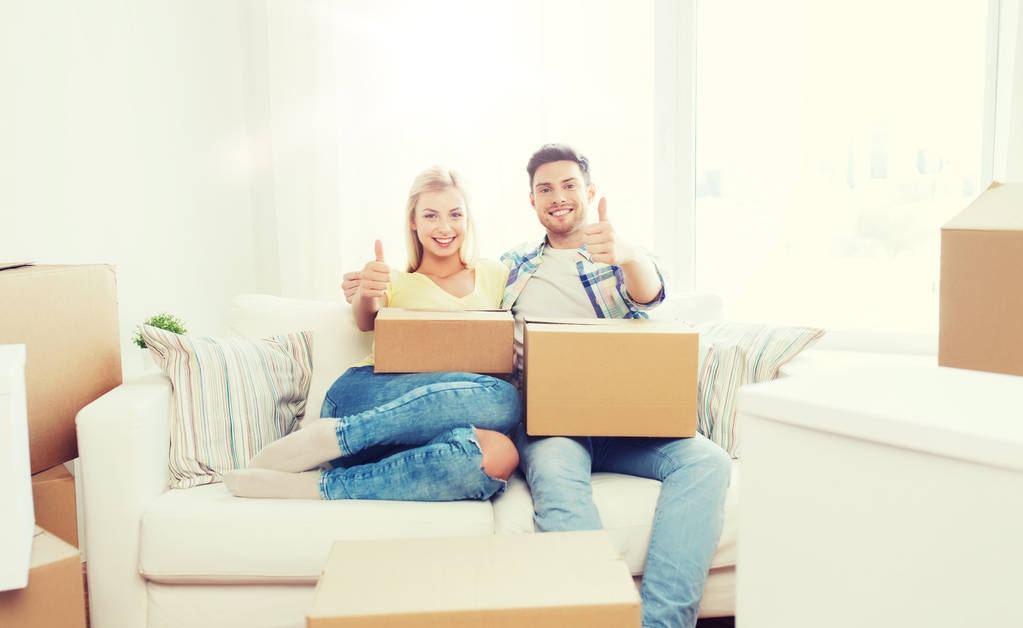 happy couple with boxes showing thumbs up at home - Photo, Image