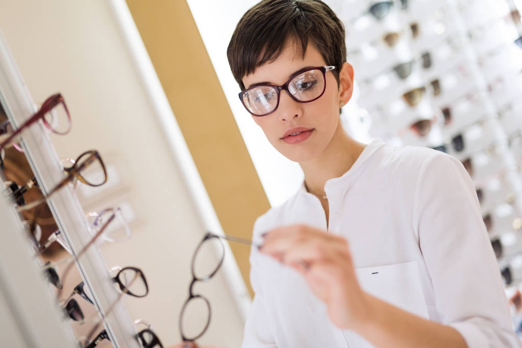 mulher está escolhendo novos óculos
 - Foto, Imagem