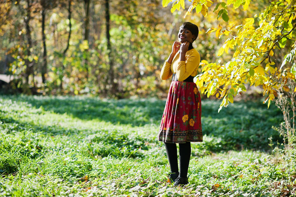 Africká americká dívka v žluté a červené šaty na podzim podzim par - Fotografie, Obrázek