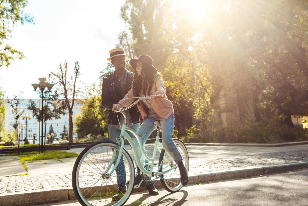 Namorado ajudando namorada andar de bicicleta
 - Foto, Imagem