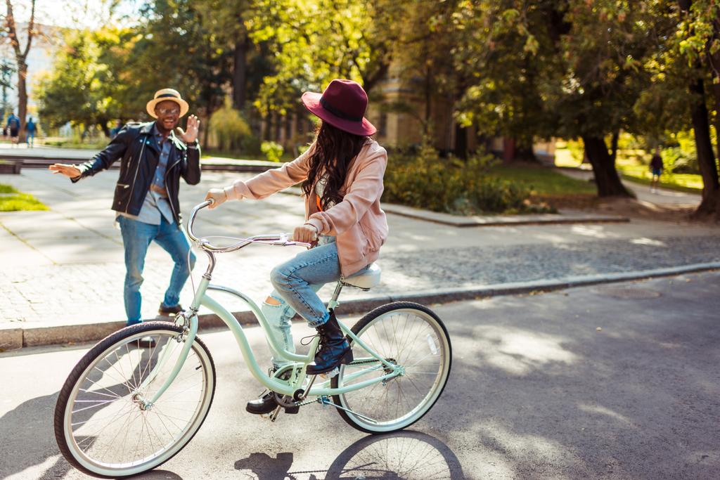 Fidanzata in sella alla bicicletta e fidanzato smorfia
 - Foto, immagini