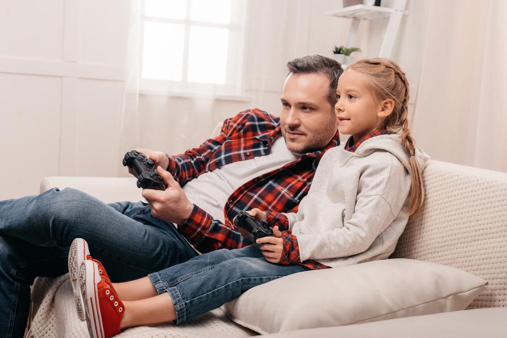 father and daughter playing with joysticks - Photo, Image