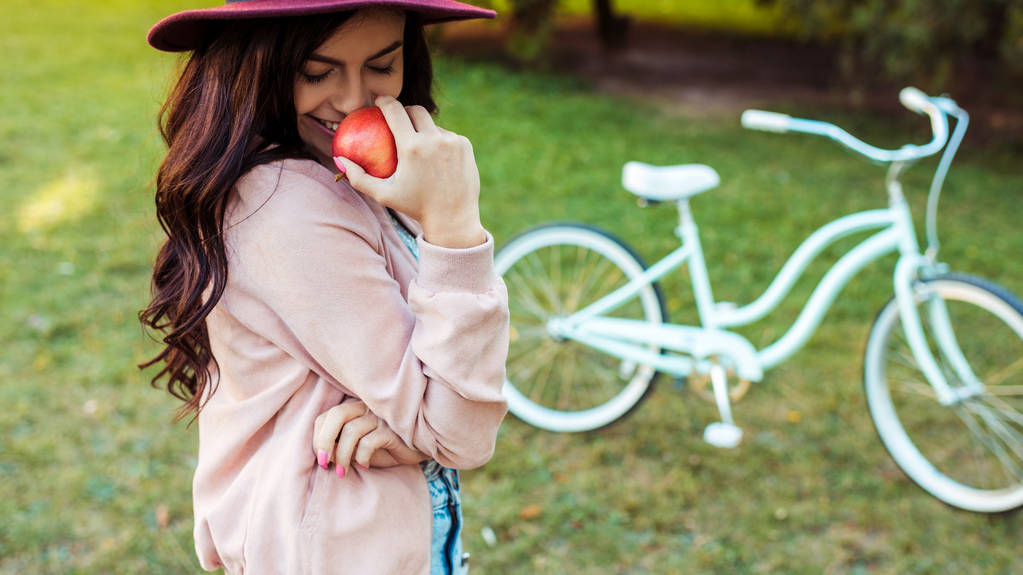 mulher de chapéu segurando maçã vermelha
  - Foto, Imagem