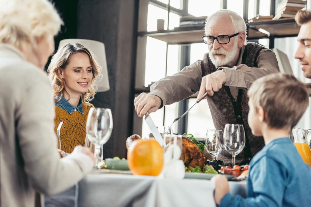 grandfather cutting turkey for family - Photo, Image
