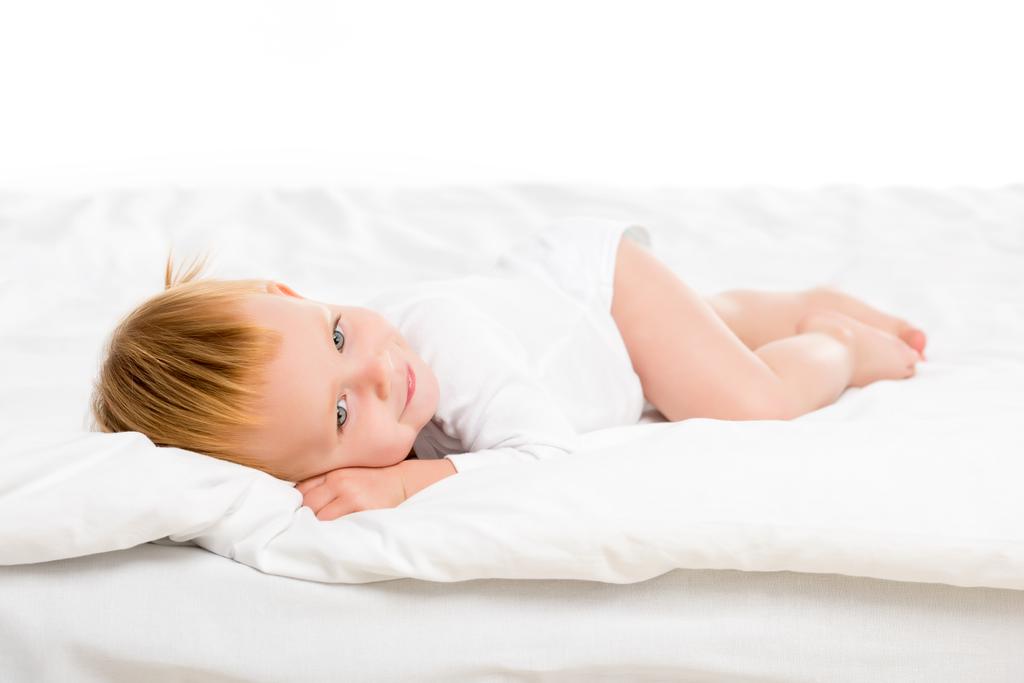 ребенок, лежащий на кровати - Фото, изображение