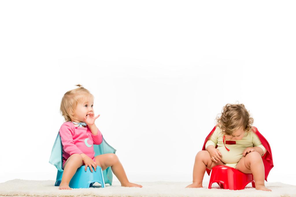 niños pequeños sentados en macetas
 - Foto, imagen