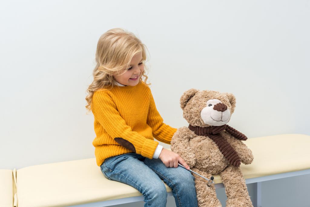 girl doing neurology examination of teddy bear - Photo, Image