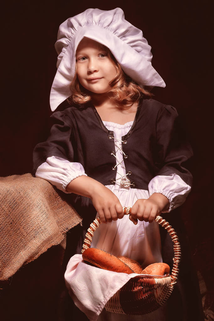 une fille dans une robe antique est debout à la table avec un pique-nique
 - Photo, image
