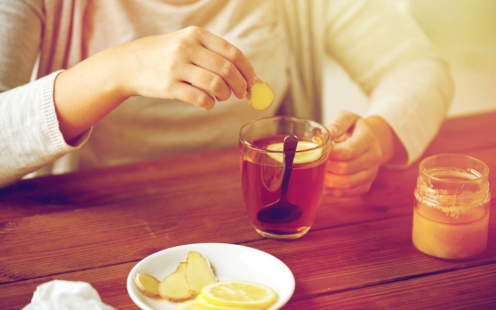 レモンと紅茶に生姜を追加する女性のクローズ アップ - 写真・画像