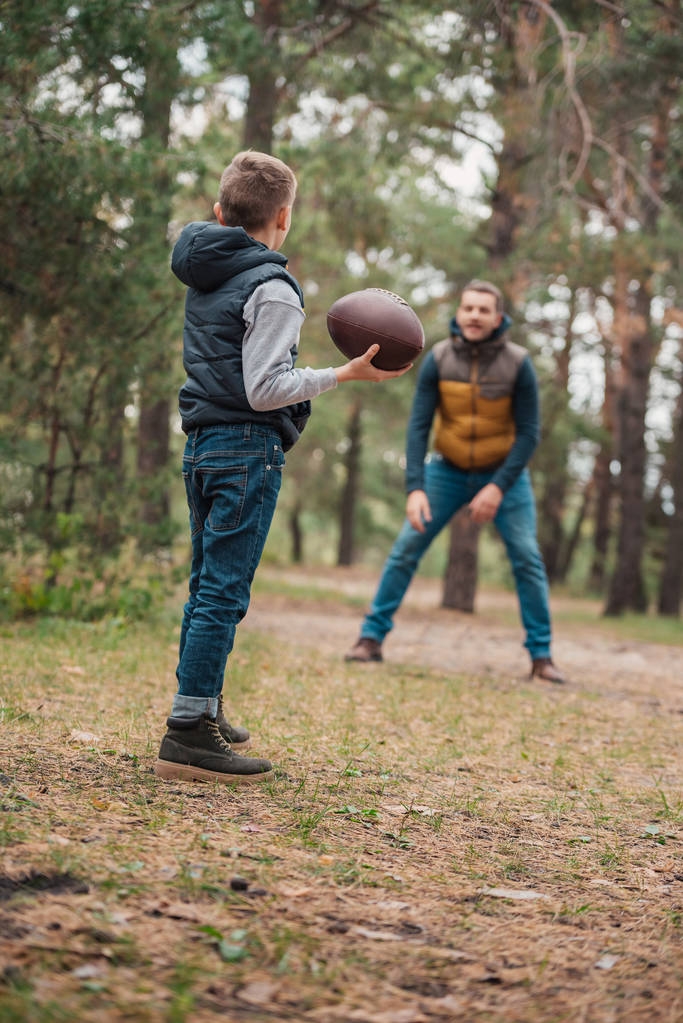 otec a syn hraje s míčem v lese - Fotografie, Obrázek