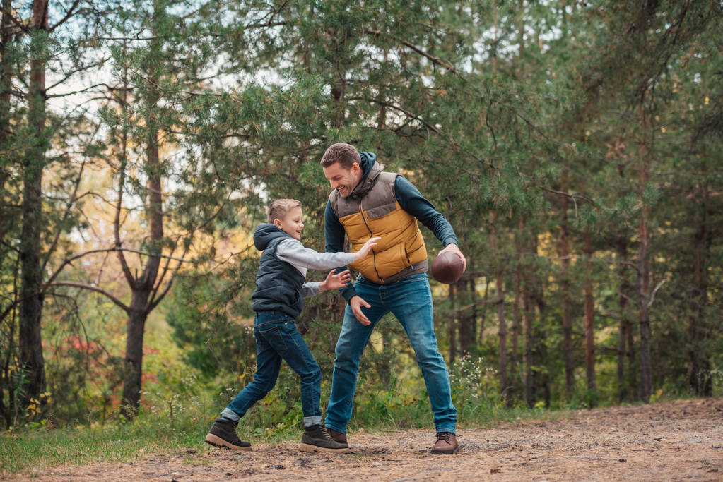 πατέρας και γιος παίζει με μπάλα στο δάσος - Φωτογραφία, εικόνα