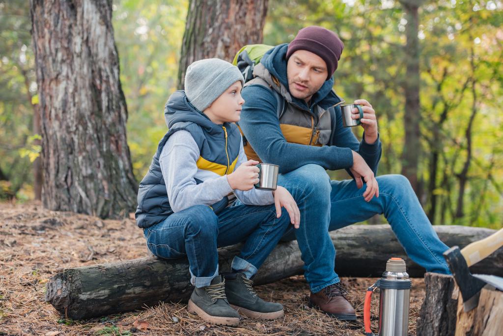 Isä ja poika juomassa teetä metsässä
 - Valokuva, kuva