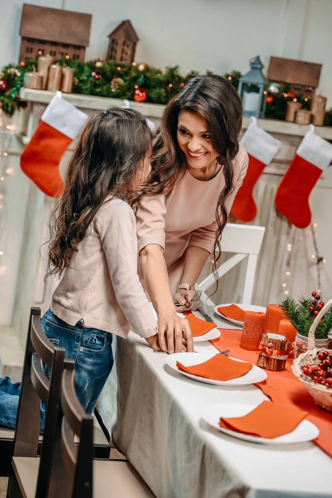 μητέρα και κόρη διακοσμώντας το χριστουγεννιάτικο τραπέζι - Φωτογραφία, εικόνα