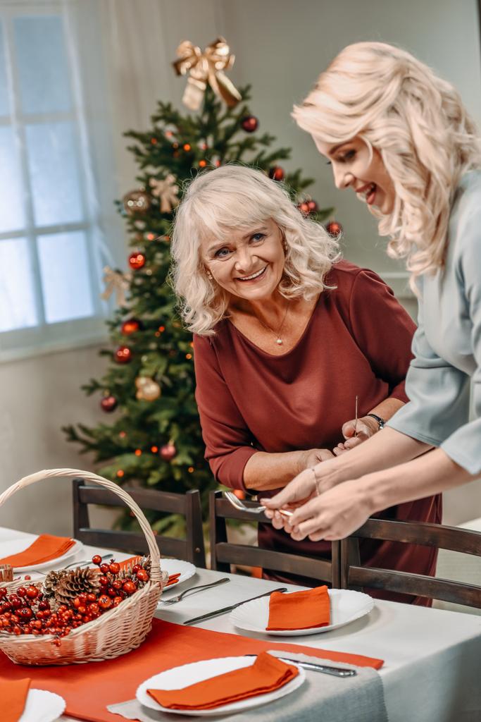 donne che decorano tavola di Natale
 - Foto, immagini