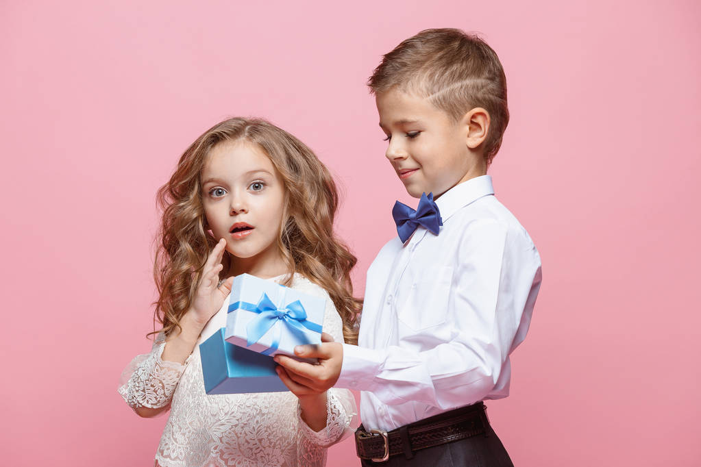 Boy and girl standing in studio on pink background - Photo, Image