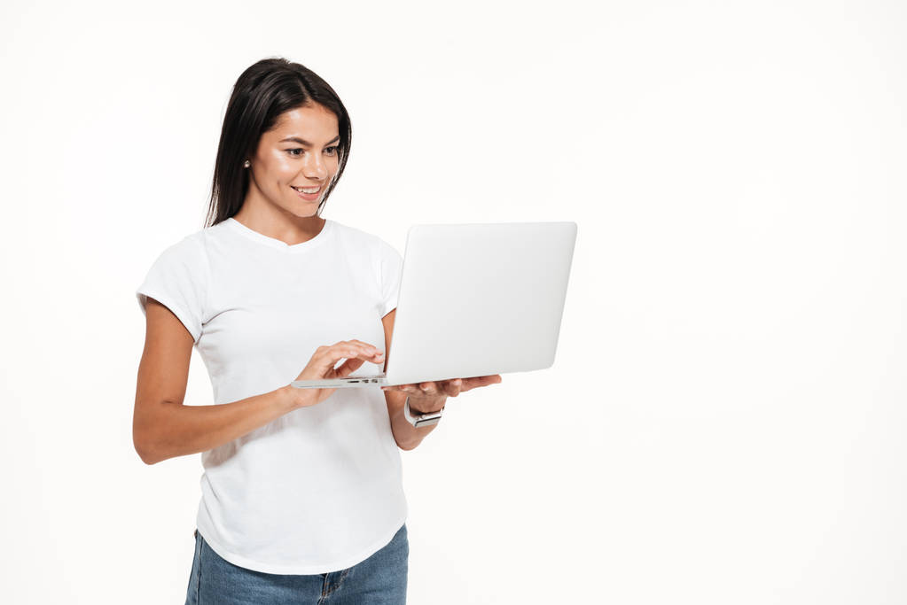 Muotokuva onnellinen nainen käyttää kannettavaa tietokonetta seistessä
 - Valokuva, kuva