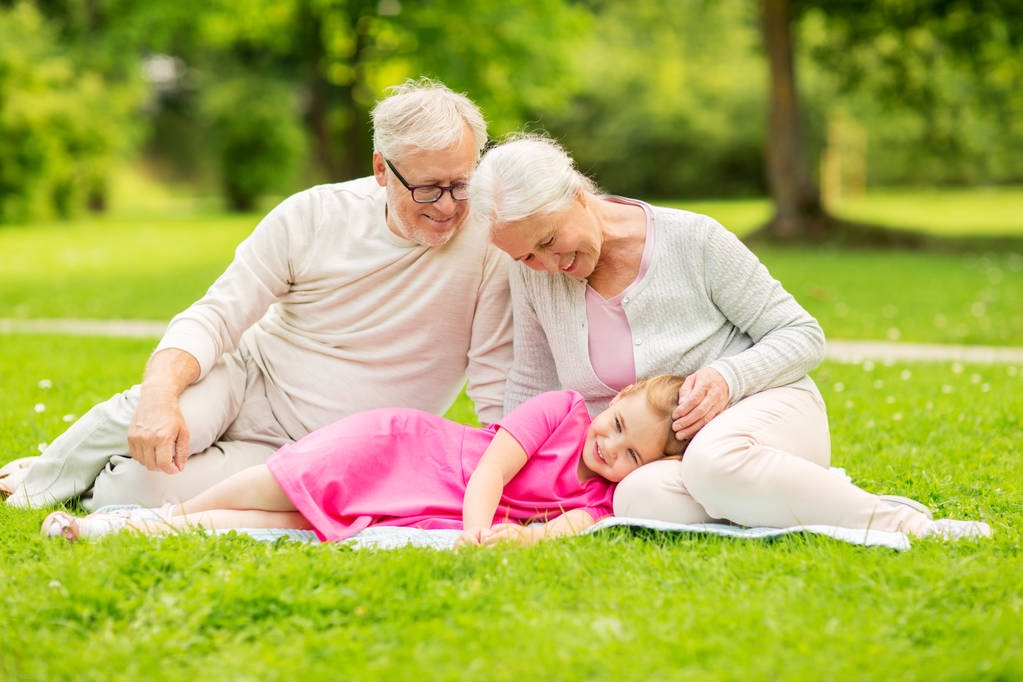 Senior grootouders en kleindochter op park - Foto, afbeelding