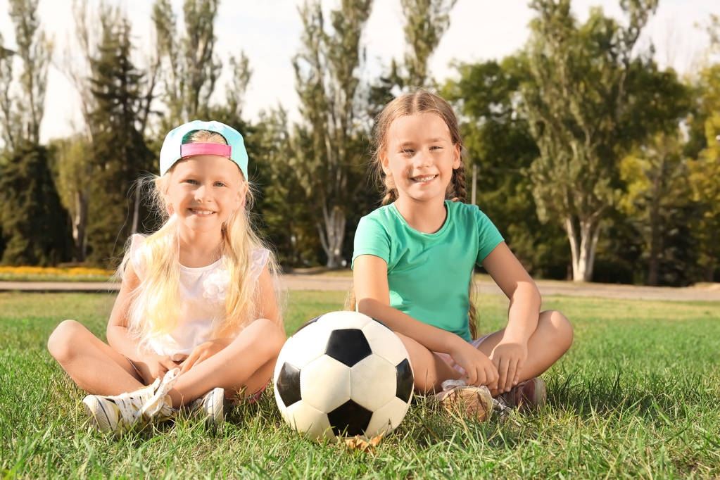 Słodkie dzieci z piłki nożnej na trawniku - Zdjęcie, obraz